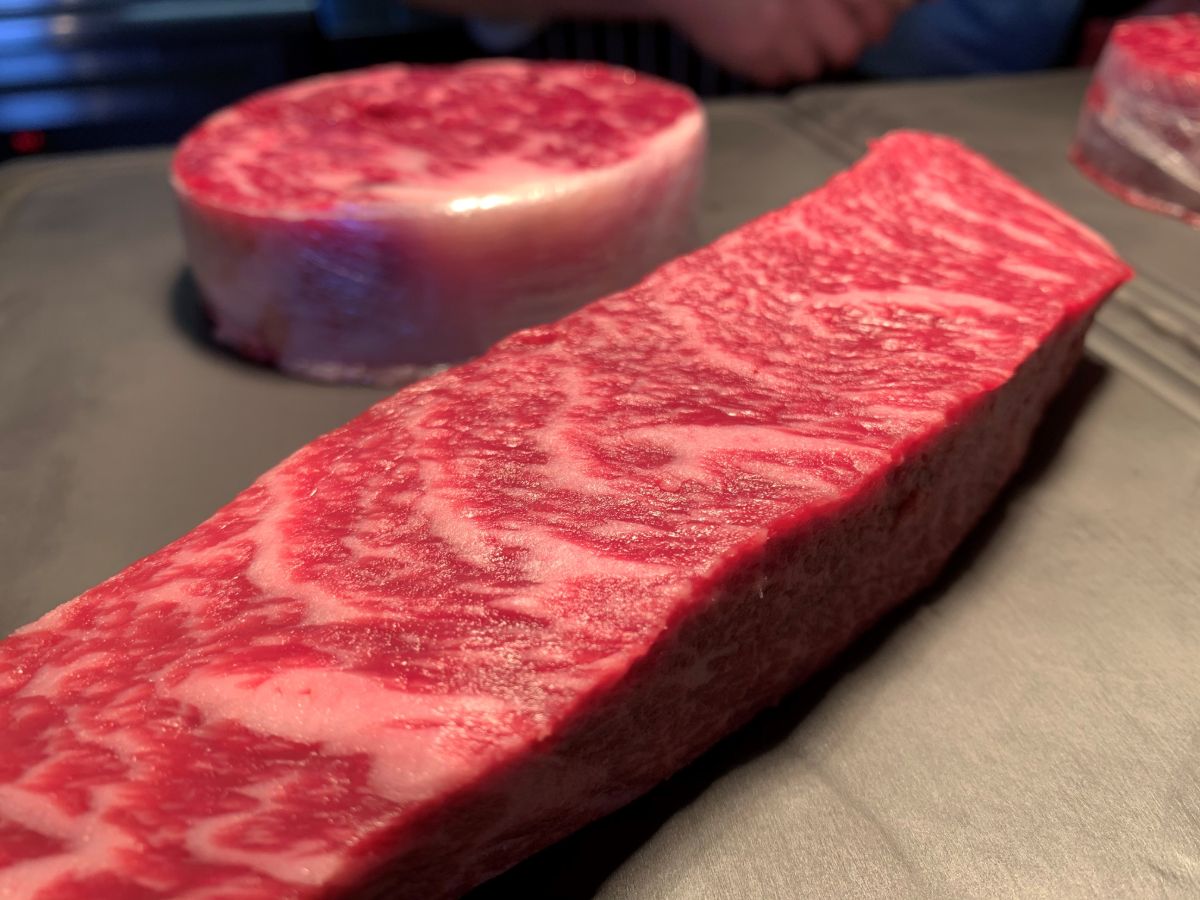 Slabs of raw wagyu steak on a surface.