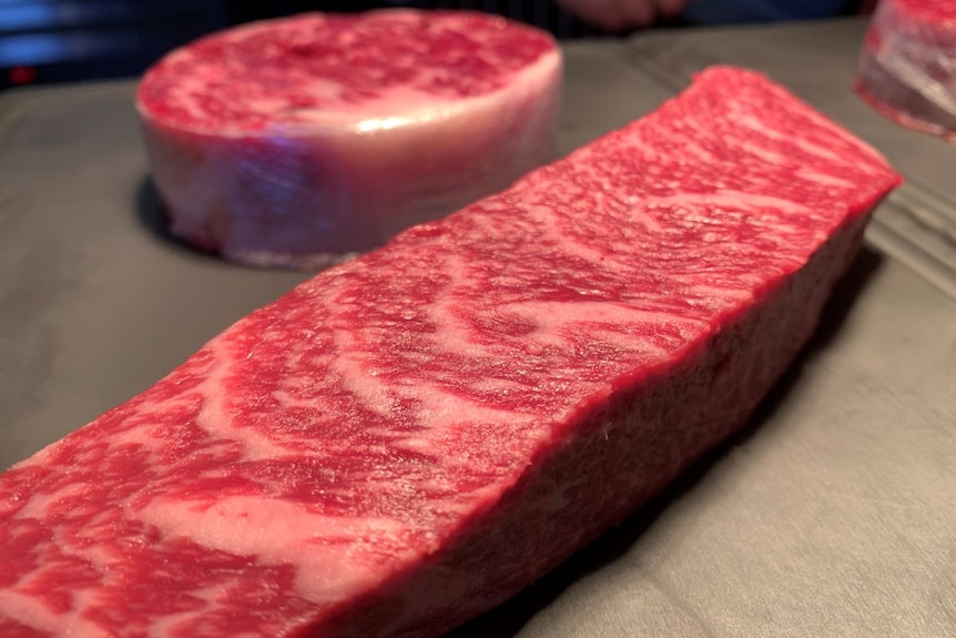 Slabs of raw wagyu steak on a surface.