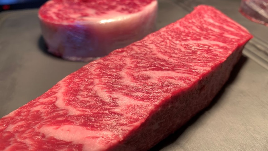 Slabs of raw wagyu steak on a surface.