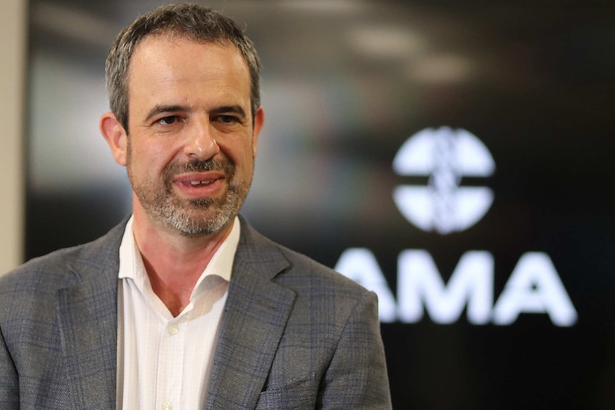 A mid shot of AMA president Omar Khorshid talking during an interview in front of an AMA sign on a wall.