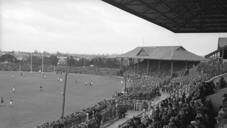 A crowd watches a football game at Subiaco Oval, 1945-1950.