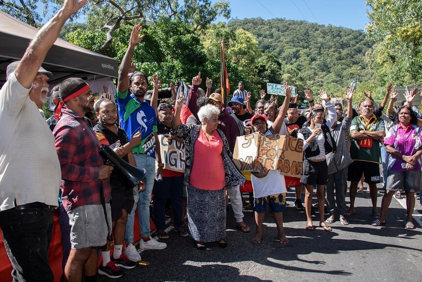 A group of colourfully dressed Indigenous protesters gathered at a police checkpoint.