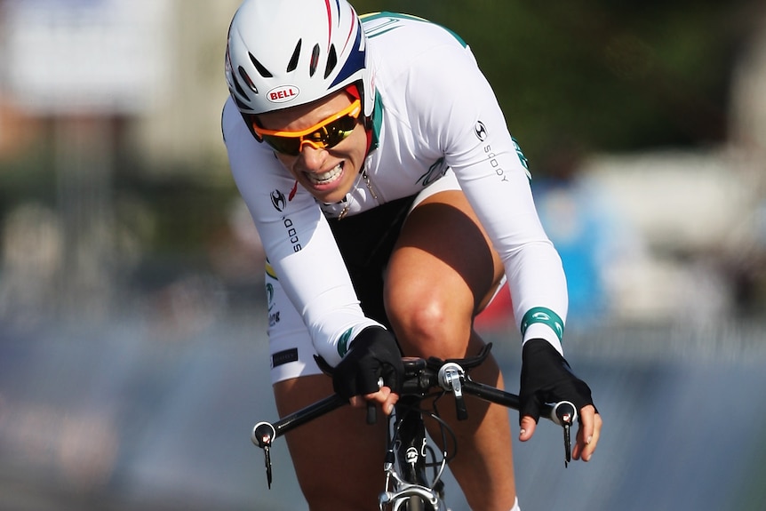 Bridie O'Donnell rides a time trial bike and grimaces