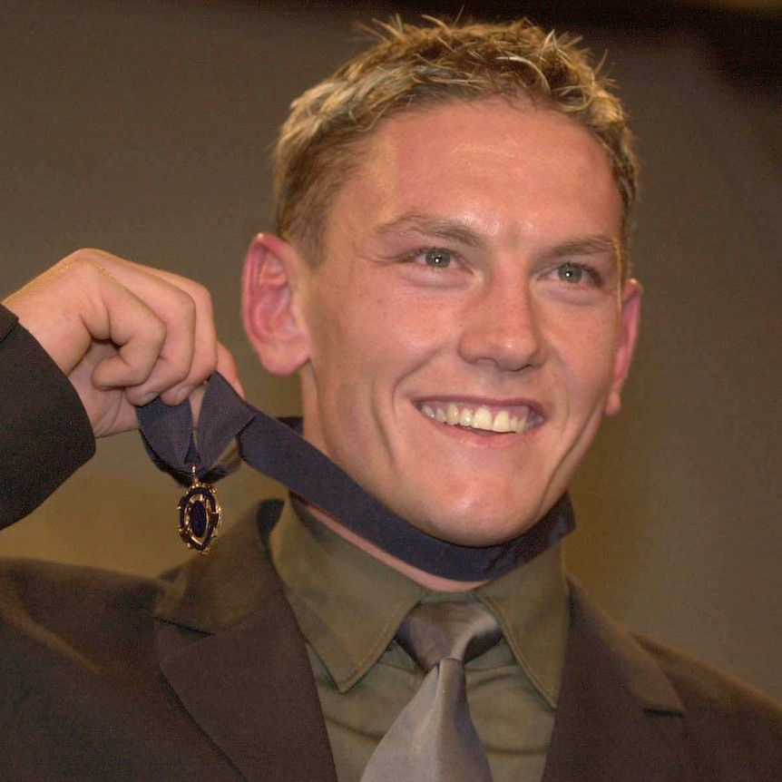 Melbourne Demons player Shane Woewodin smiles while holding up the 2000 Brownlow Medal.
