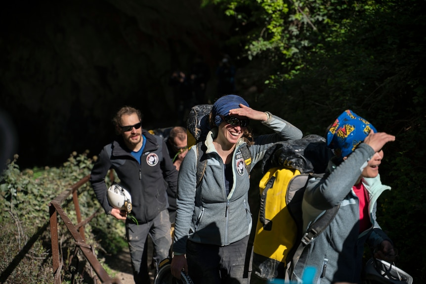 Members of the French team emerge from the cave