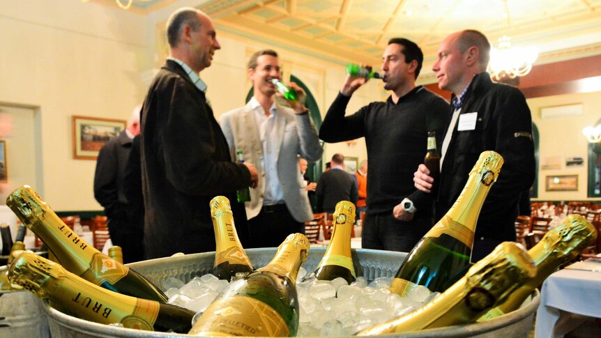 Diggers and dealers mining conference delegates drinking in front of a champagne bucket