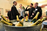 Diggers and dealers mining conference delegates drinking in front of a champagne bucket