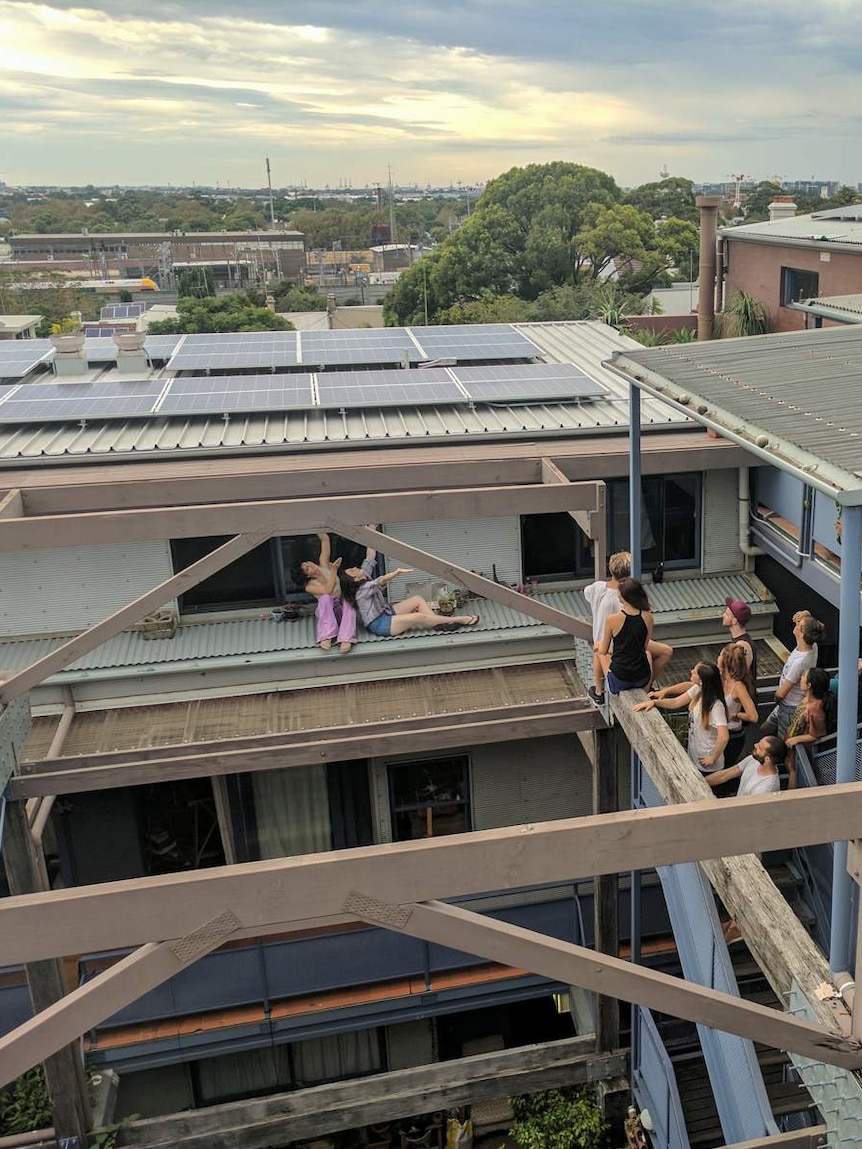 Stucco residents posing for photograph with rooftop solar panels.