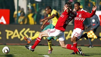 South Africa's Katlego Mphela scores ahead of Denmark's Per Kroldrup (C) and Patrick Mtiliga (R) during their international f...