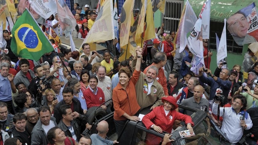 Mr Lula (C) raises the hand of Dilma Rousseff (C, in orange) during a campaign rally in Sao Bernardo do Campo, south of Sao Paulo.