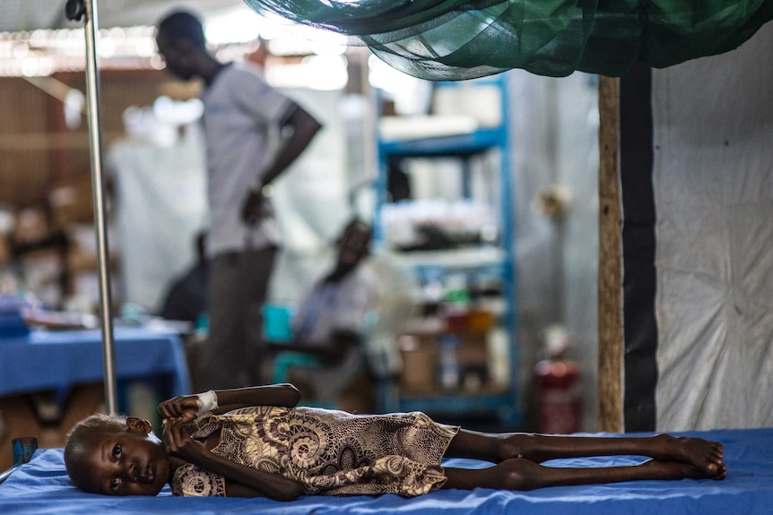 South Sudanese girl Nyajima-guet lies malnourished in a hospital bed