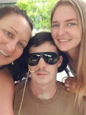 Young man and his young sister and mum doing a selfie, he still has his nose tube in and sunnies on.