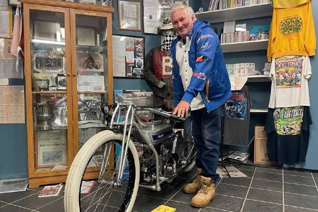 A man with an old motorbike.