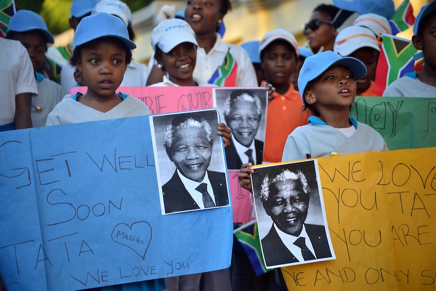 South African children hold messages of support for Nelson Mandela