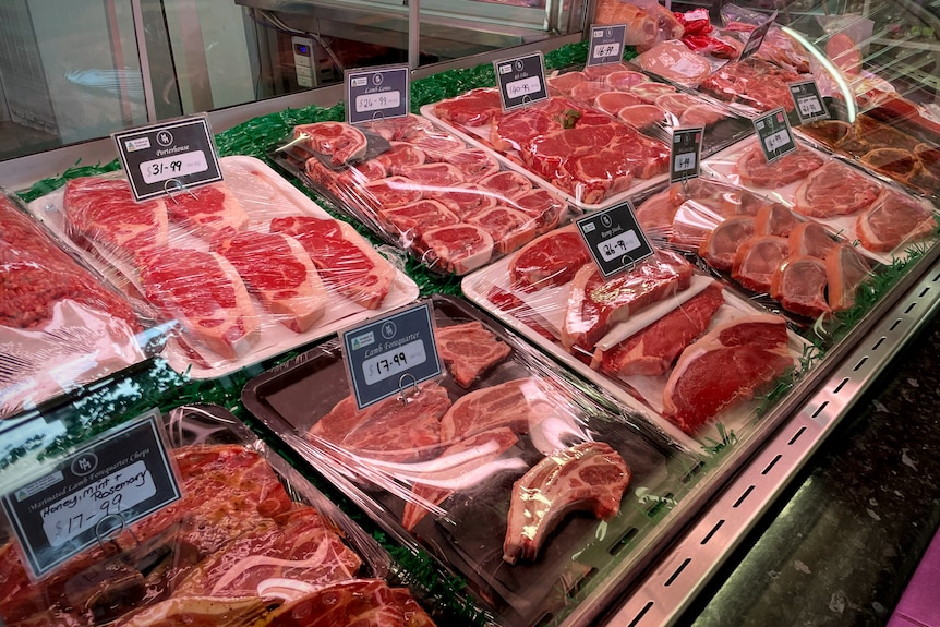 Meat in butcher display with plastic covering it