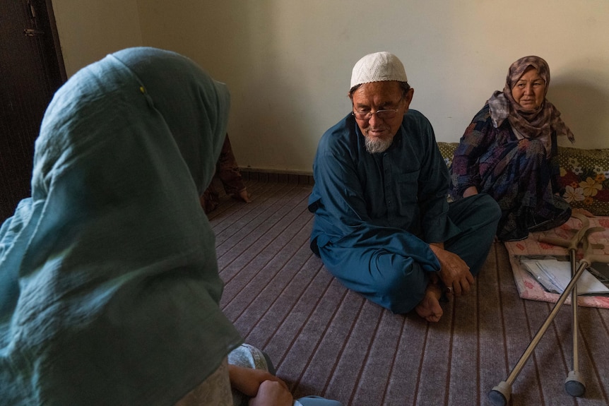 People sit on the carpeted floor. 