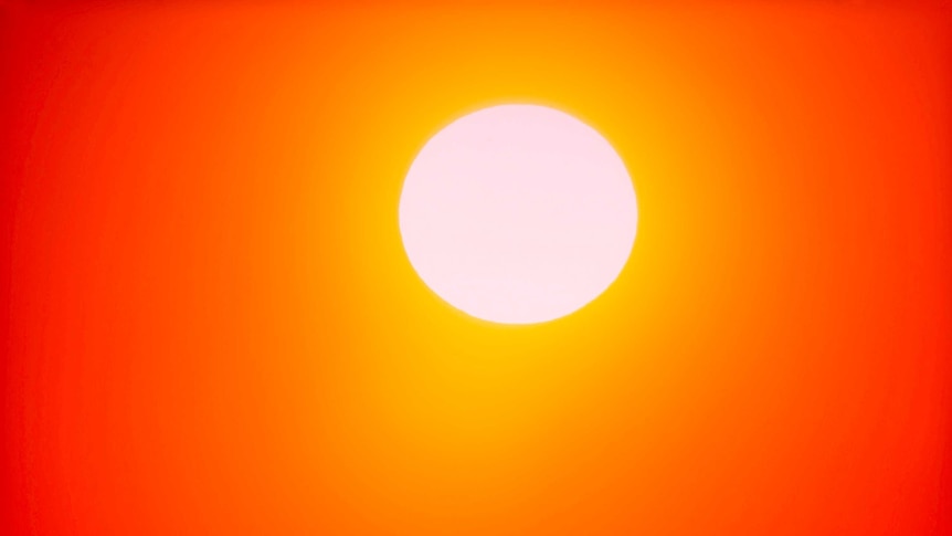 A sun blazes against red orange sky.