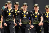 A group of serious looking female cricketers walk off the ground during an ODI match.