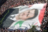 Syrian demonstrators unfurl a giant portrait of Syrian President Bashar al-Assad.