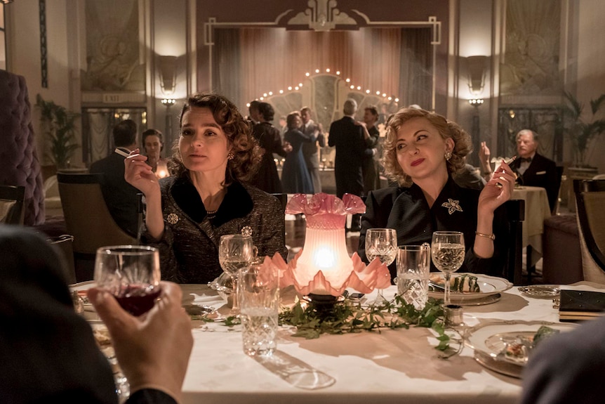 Colour still of Shirley Henderson and Nina Arianda sitting at a table in 2018 film Stan and Ollie.