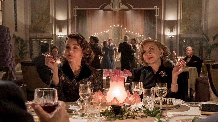 Colour still of Shirley Henderson and Nina Arianda sitting at a table in 2018 film Stan and Ollie.