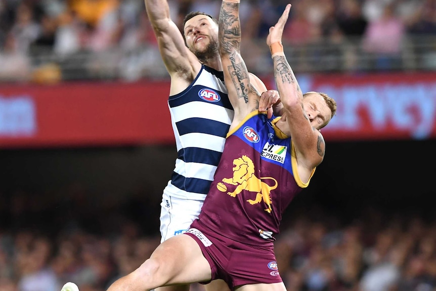 Sam Menegola and Mitch Robinson crash into each other as they reach for the ball above their heads