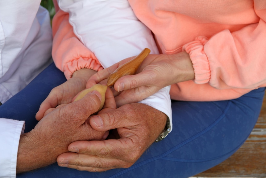 hands holding wooden birds