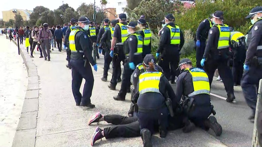 Police make handful of arrests as dozens of protesters gather at St Kilda