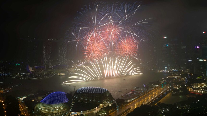 Fireworks explode over the Singapore city skyline.