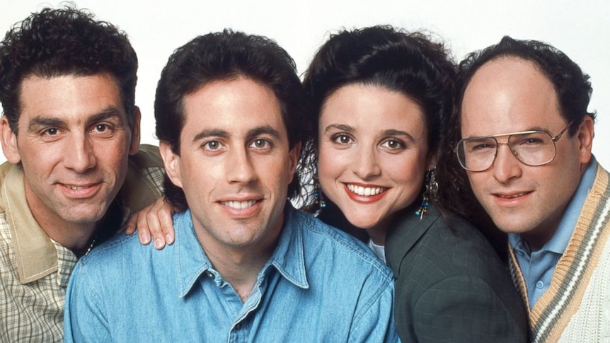 The four faces of the Seinfeld cast - Kramer, Jerry, Elaine and George - pressed close together. Each smiling and looking ahead.