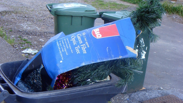 Artificial Christmas tree in a plastic wheelie bin.