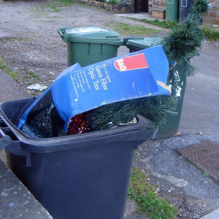 Artificial Christmas tree in a plastic wheelie bin.