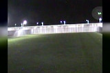 A grainy still frame from a video shows the lights of a drone over Lithgow Correctional Centre.