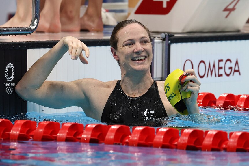 Cate Campbell smiles and points while in the pool