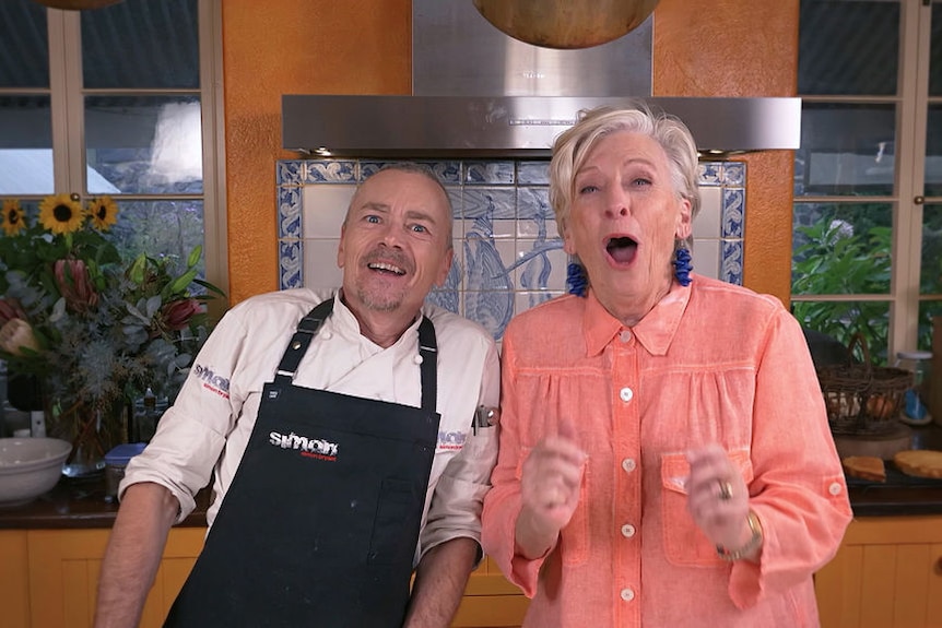 Simon Bryant and Maggie Beer bake a cake in a kitchen with yellow cabinets