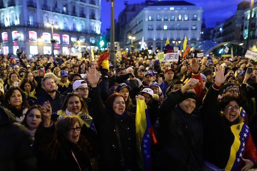 A crowd of Venezuelan protesters assemble at night.