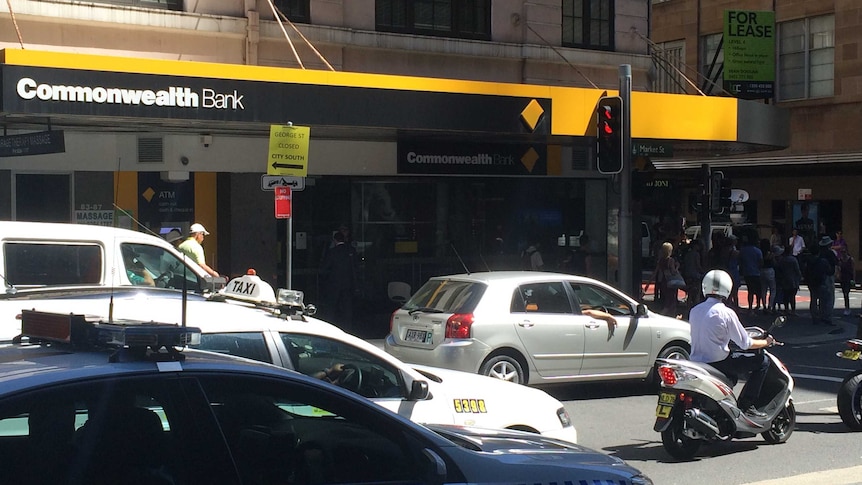 A Commonwealth Bank building on the corner of Market and Castlereagh Street in the CBD with some traffic in front.