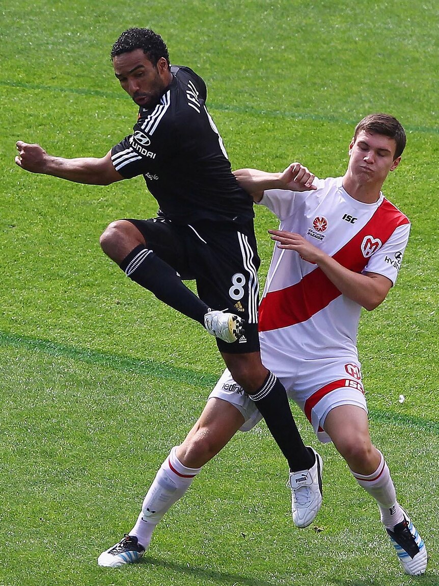 Wellington's Paul Ifill kicks the ball away from Melbourne's Curtis Good during their round 17 A-League match