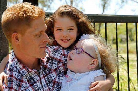 Rob Humphris holds daughters Ellowyn and Cambrie outside.