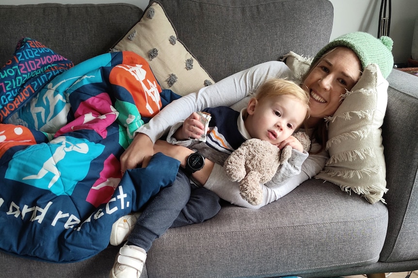Jess Stenson lying on the couch with her son