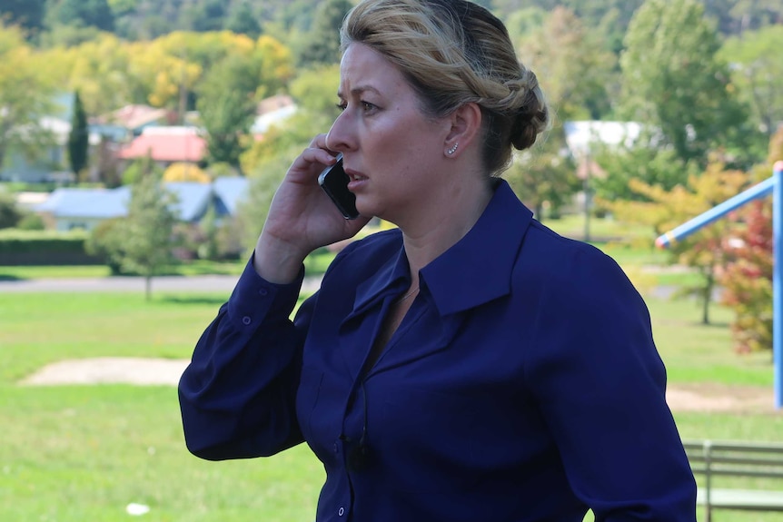 Detective Senior Constable Jane Prior speaking on the phone in a park.