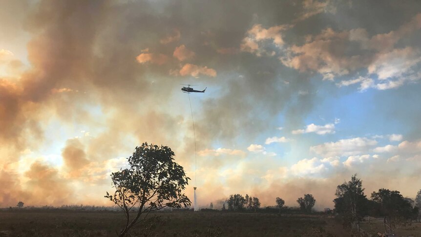 A helicopter water bombs a fire off Lemon Tree Pass Road, south of Tanilba Bay.