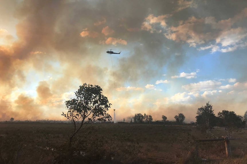 A helicopter water bombs a fire off Lemon Tree Pass Road, south of Tanilba Bay.