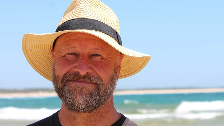 A man, David McDonald, stands at a beach.