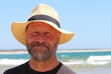 A man, David McDonald, stands at a beach.