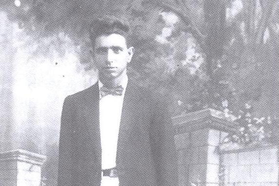 An archive photo of an young man with dark features and a bowtie, looking at the camera