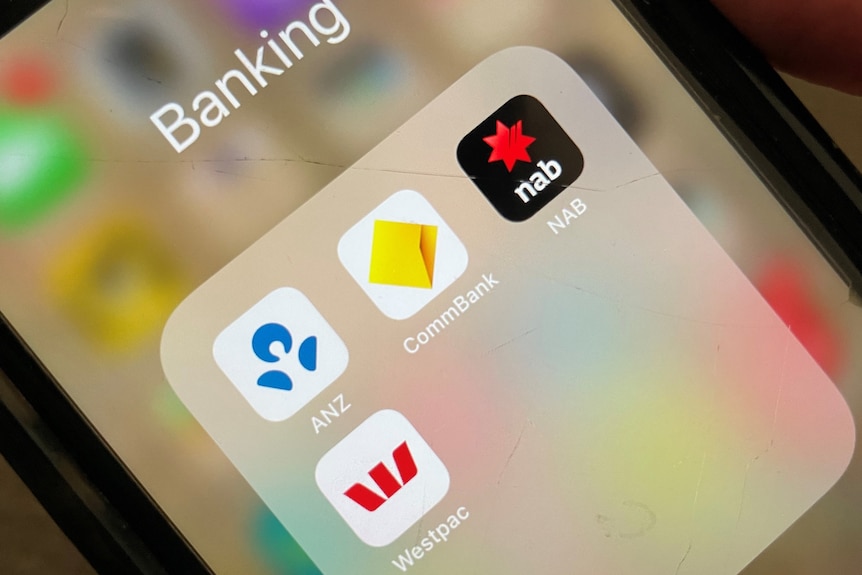 A person holds an iPhone with the banking apps for ANZ, Commonwealth Bank, NAB and Westpac open.