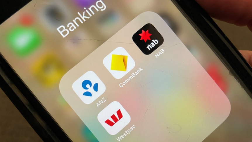 A person holds an iPhone with the banking apps for ANZ, Commonwealth Bank, NAB and Westpac open.