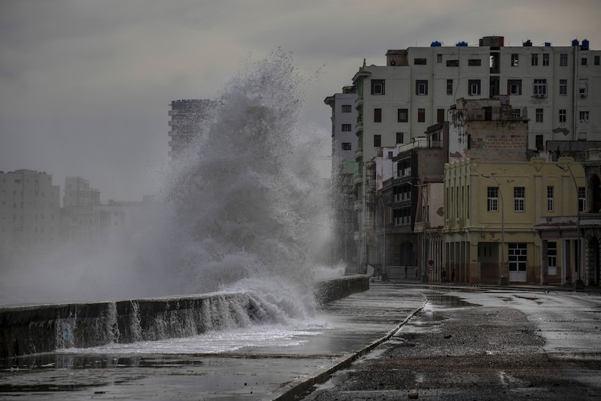 Water sprays as a wave crashes against a wall