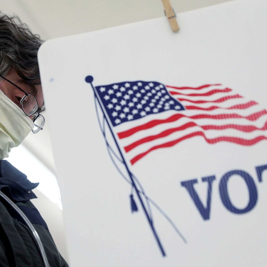 Voter Fred Hoffman fills out his ballot during the primary election in Ottawa, Illinois
